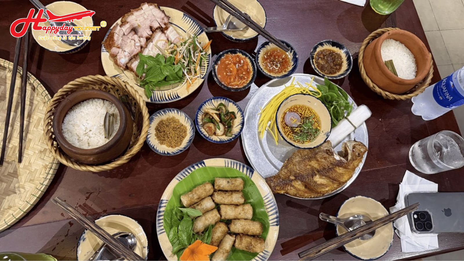 Bàn tiệc cơm niêu truyền thống với niêu cơm nóng, thịt quay, cá chiên và các món ăn kèm hấp dẫn