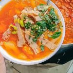 Bát bánh canh Nam Phổ sền sệt màu đỏ cam hấp dẫn với chả và rau thơm ở Huế