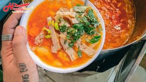 Bát bánh canh Nam Phổ sền sệt màu đỏ cam hấp dẫn với chả và rau thơm ở Huế