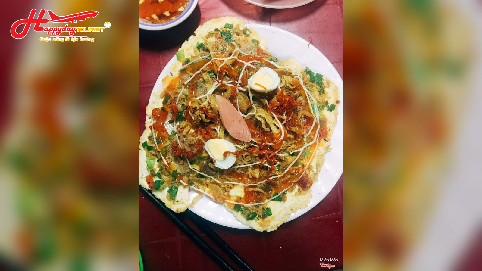 Chiếc bánh ép Huế nóng hổi trên đĩa kèm trứng cút, hành lá và chén nước mắm ớt bên cạnh