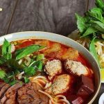 Tô bún bò Huế đầy đặn với thịt bò, chả cua và rau sống ăn kèm