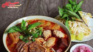 Tô bún bò Huế đầy đặn với thịt bò, chả cua và rau sống ăn kèm