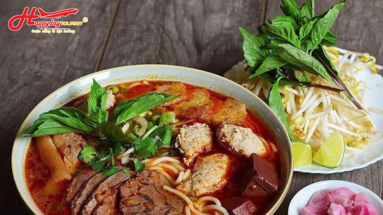 Tô bún bò Huế đầy đặn với thịt bò, chả cua và rau sống ăn kèm