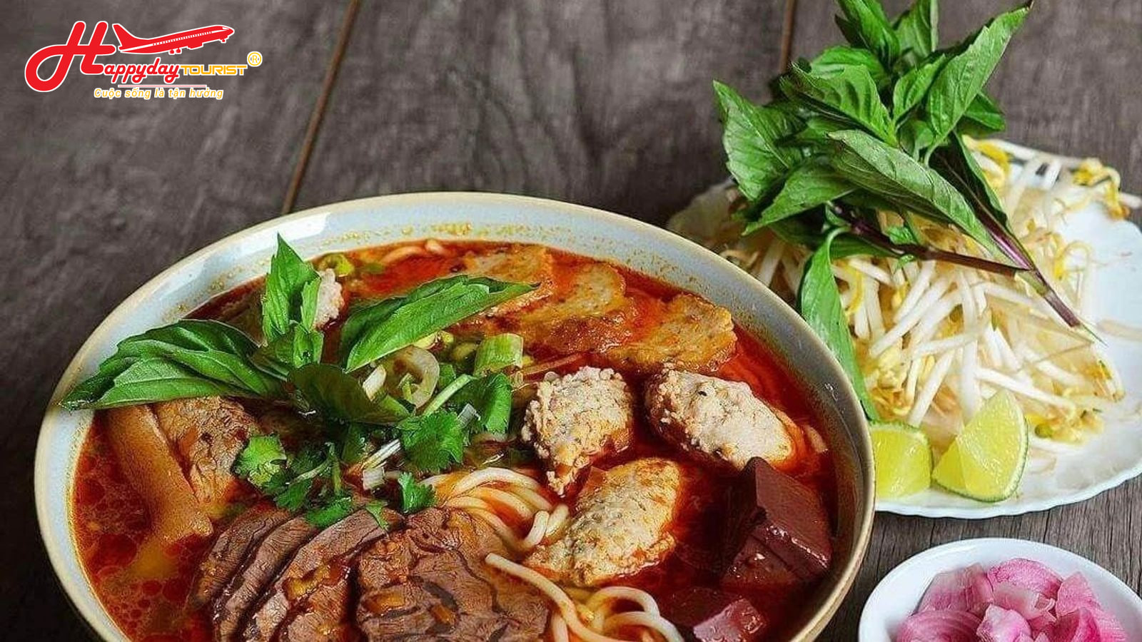 Tô bún bò Huế đầy đặn với thịt bò, chả cua và rau sống ăn kèm